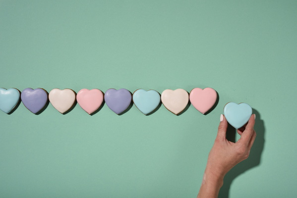 Heart-Shaped Cookies Lie in Line and Girl Holding One Of Them